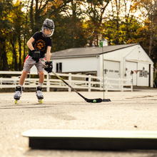 Load image into Gallery viewer, Bauer Modular Training Center Rebounder youth on inline skates handling ball with hockey stick
